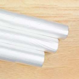 Rolls of clear polyethylene bags lying on a wooden bench.
