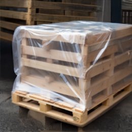 A stack of timber on a pallet covered with clear polyethylene sheeting.