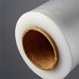 A roll of clear stretch film stood on end, its kraft cardboard core facing the camera.