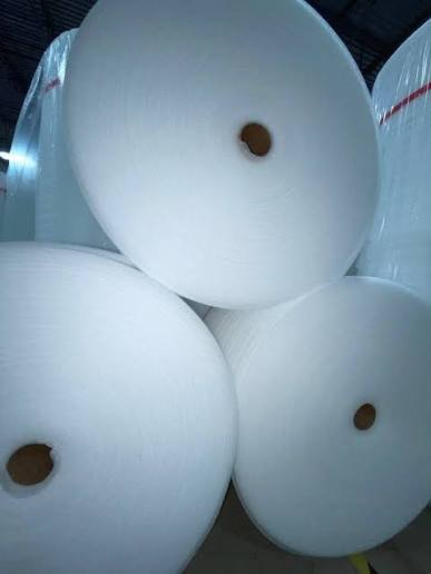 Three large rolls of white polyethylene foam stacked together, their cardboard cores facing the camera.